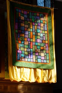 Der Quilt, das Geschenk für Heidi Wäger, hängt über dem Altar.